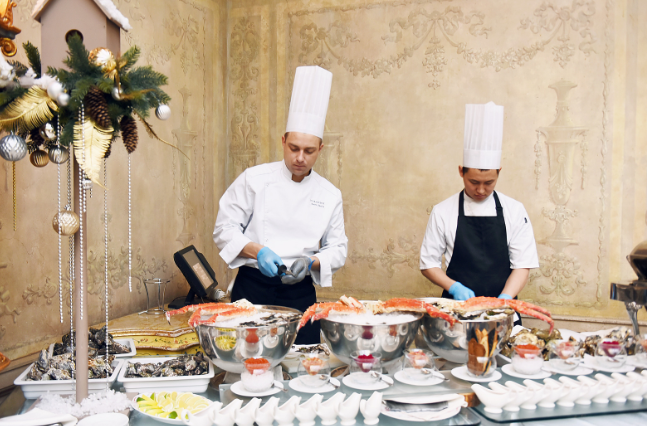 Two chefs arranging commercial kitchen equipment for a catering event